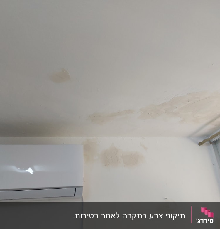 כתמי צבע על תקרה וקיר ליד חלון